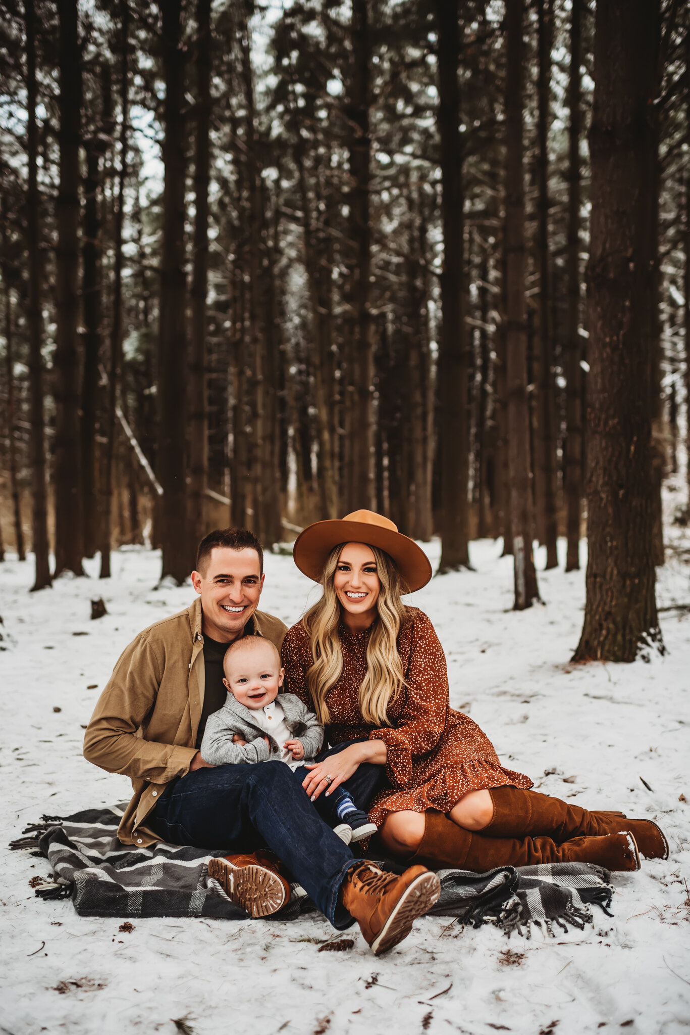 peoria IL family photos-family sits in snow with tall trees