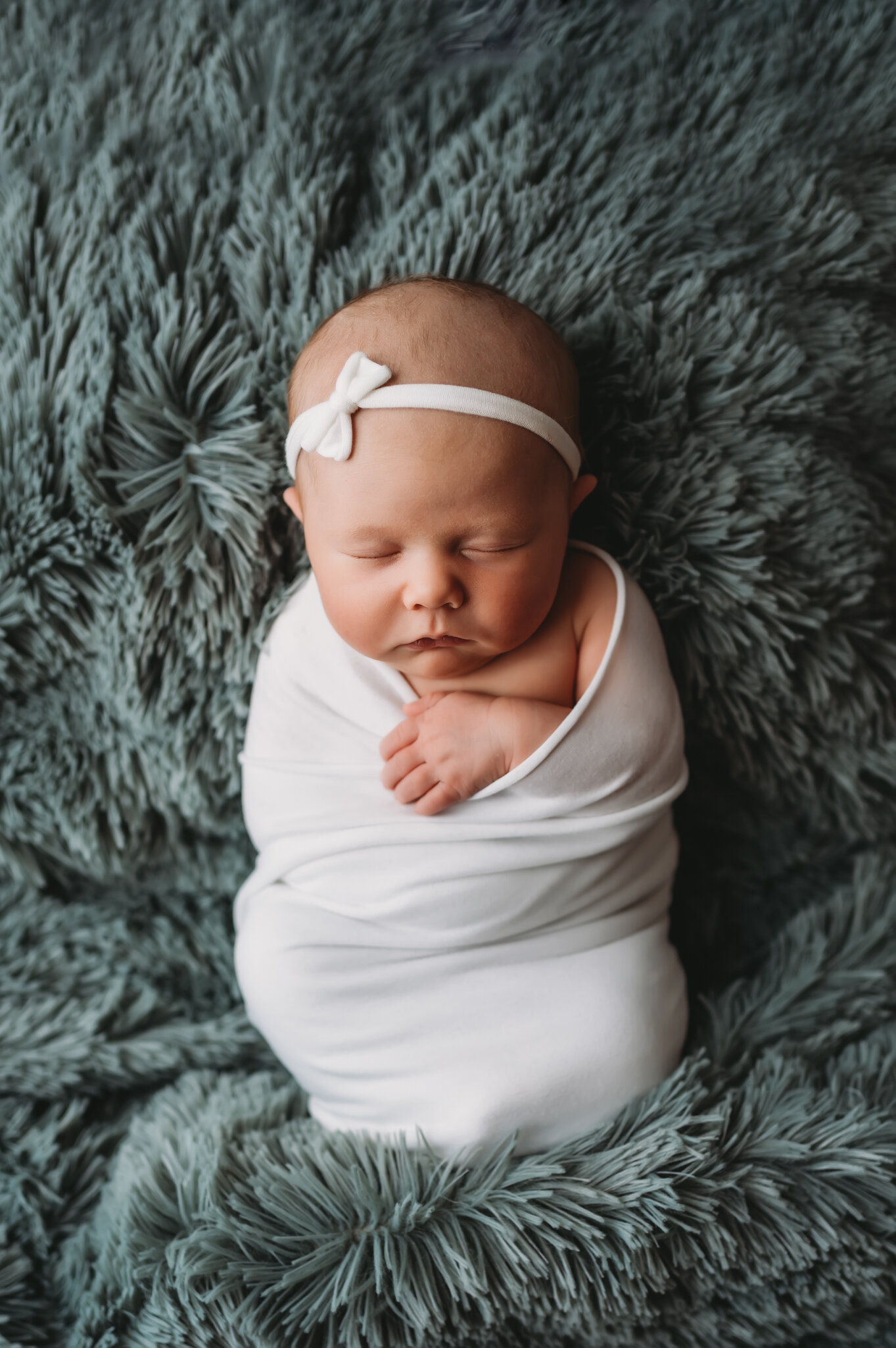Newborn photographer in central illinois, baby girl with little white bow and white wrap