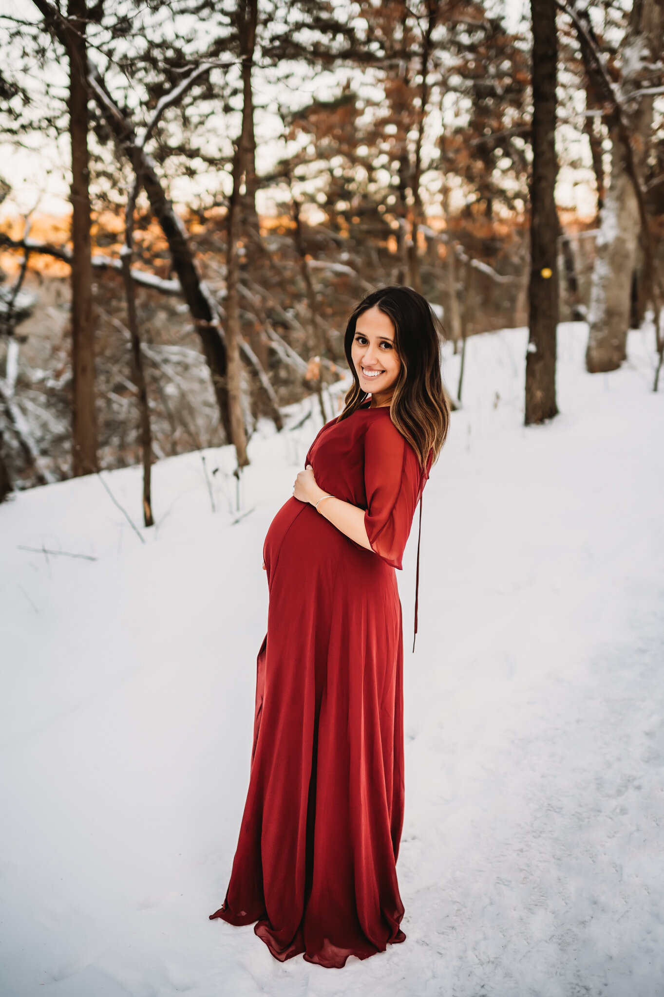 peoria maternity photographer pregnant mom stands in snow