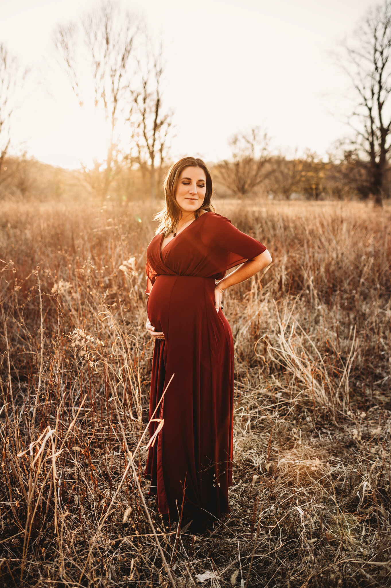 East Peoria Maternity Photographer, pregnancy photoshoot, mom stands in front of sunset