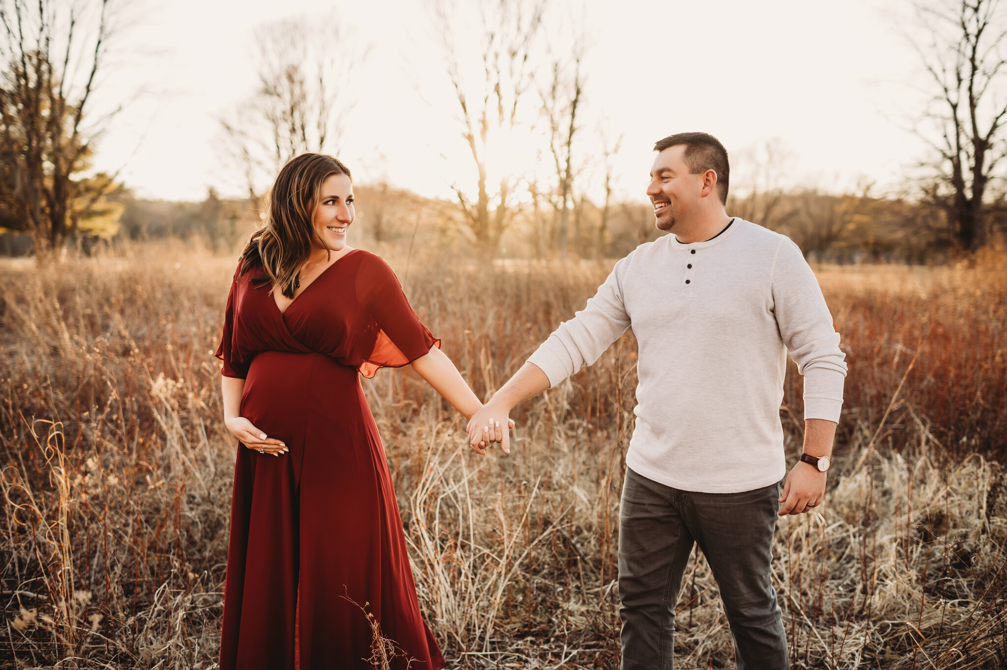 dunlap photographer, maternity photo session, couple walks through tall grasses