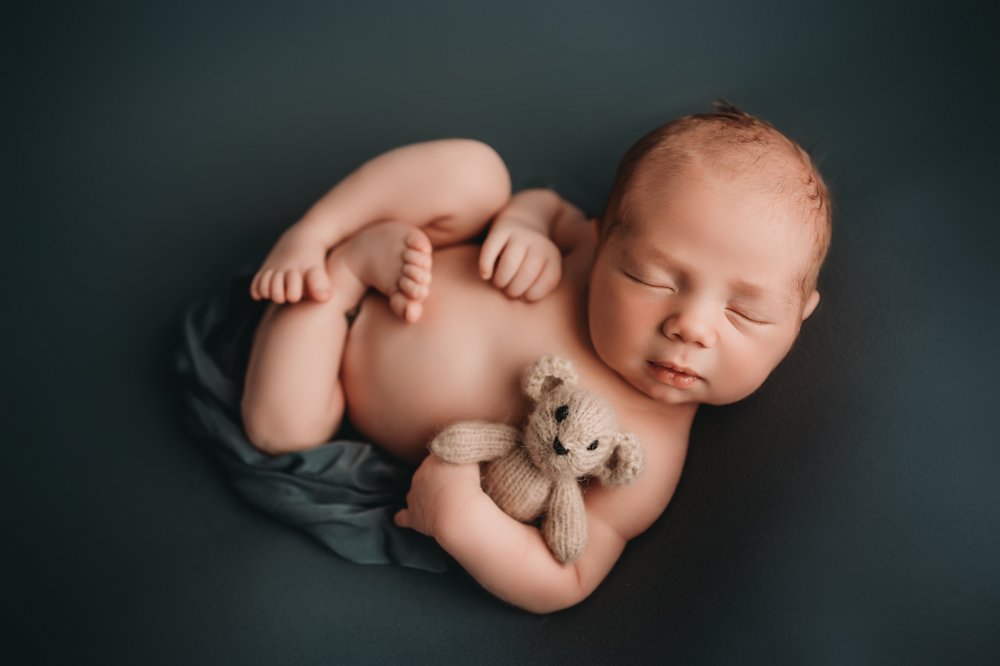 Newborn baby holds teddy bear.jpg