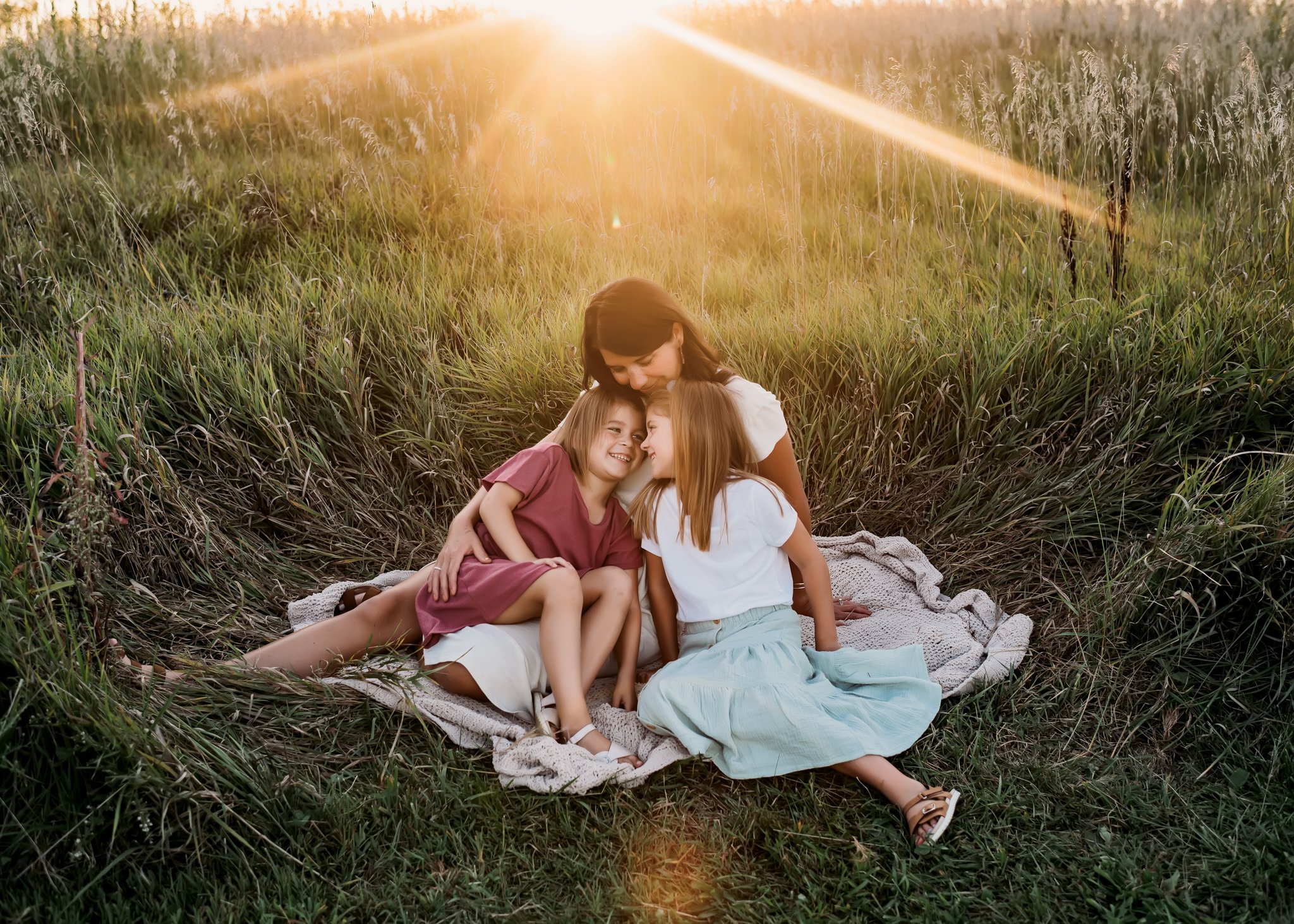 mom sits with daughters with sun rays.jpg