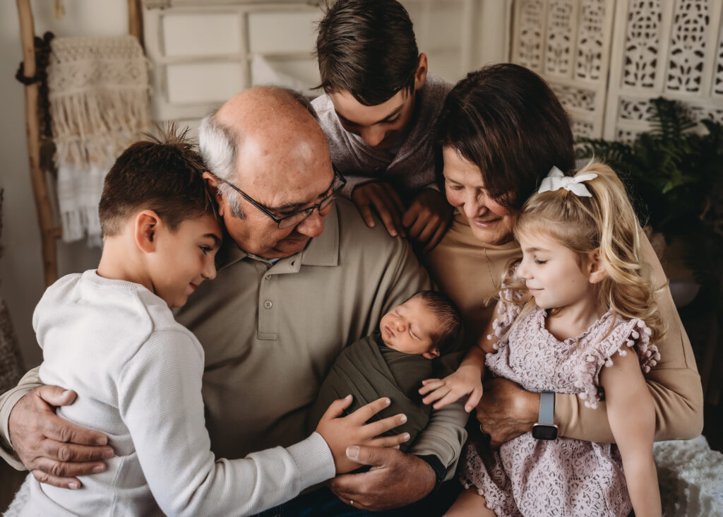 Grandparents pose with grandchildren and newborn baby