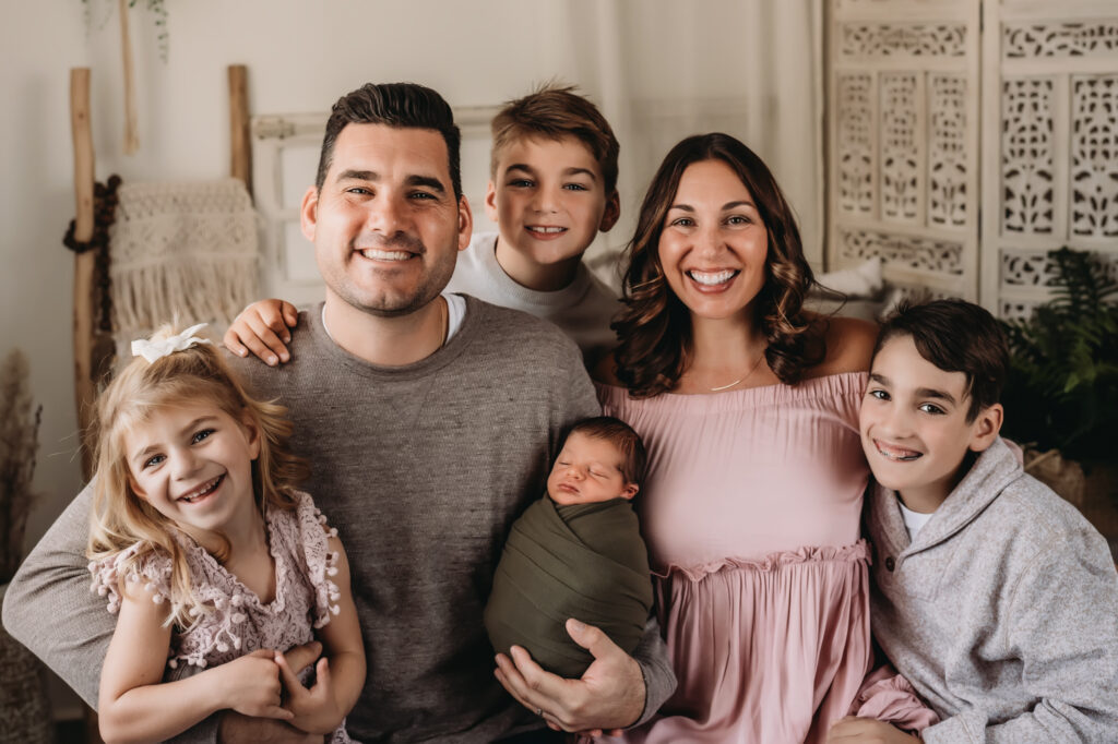 family poses with newborn son