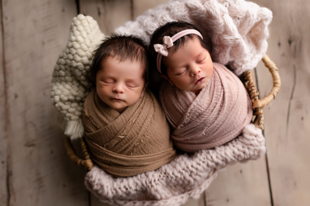 Boy and girl twins lay together in basket