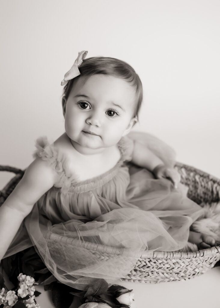 black and white photo of baby girl in basket