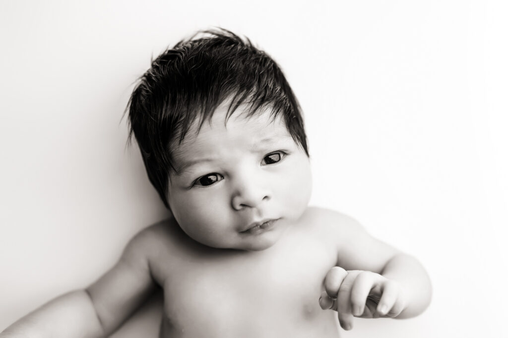 black and white photo of baby looking at camera. newborn photos in peoria