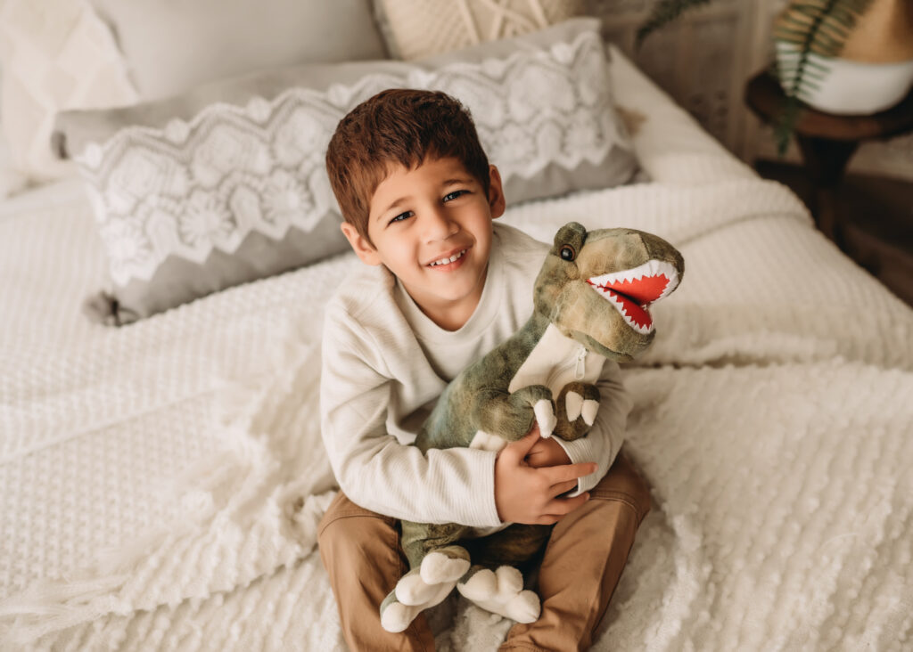 big brother holds stuffed dinosaur