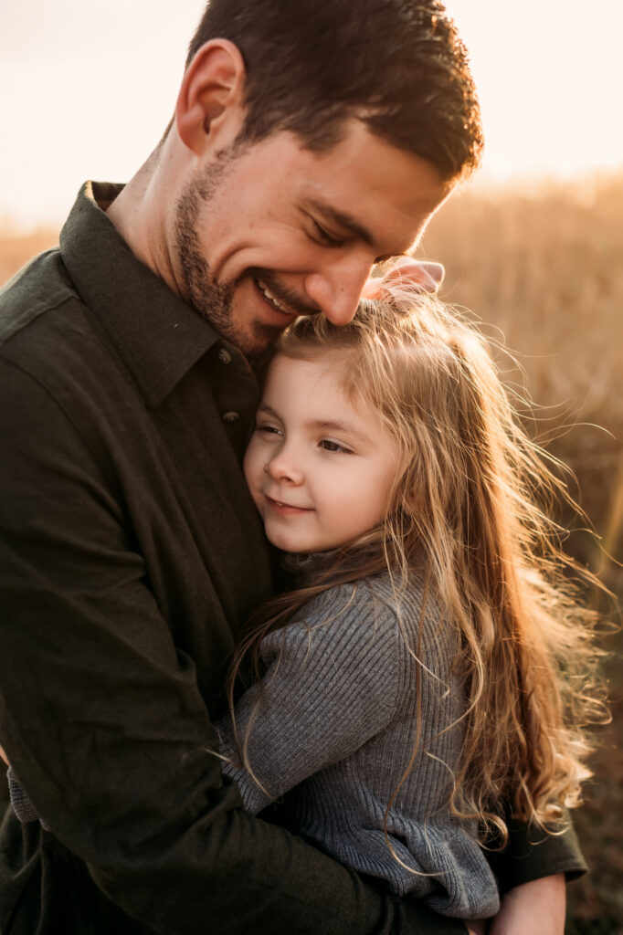 little girl with bow hugs dad